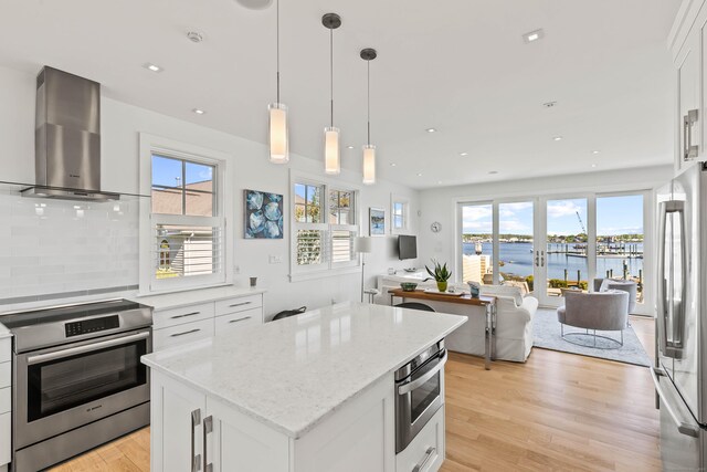 52 Old N Rd, Stonington, CT 06355 - kitchen featuring stainless steel appliances, wall chimney range hood, open floor plan, light wood-style floors, and recessed lighting