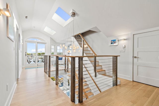 52 Old N Rd, Stonington, CT 06355 - hallway with a skylight, an upstairs landing, light wood-type flooring, vaulted ceiling, and baseboards