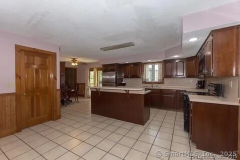 31 Bayberry Ln, Lisbon, CT 06351 - kitchen featuring range with electric stovetop, refrigerator, light countertops, healthy amount of natural light, and wooden walls