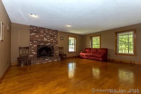 31 Bayberry Ln, Lisbon, CT 06351 - living room with wood finished floors, baseboards, and a brick fireplace
