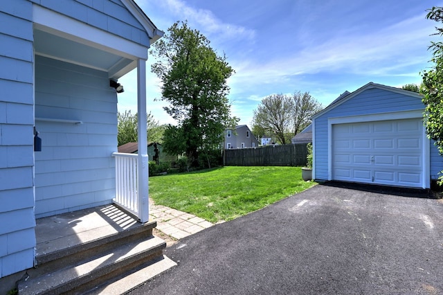 view of yard featuring an outdoor structure, driveway, and a garage