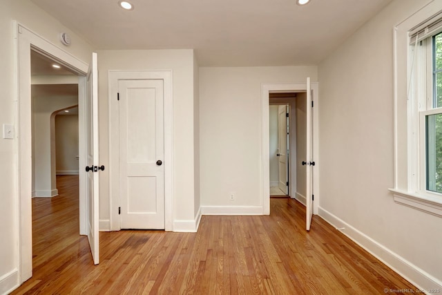 unfurnished bedroom featuring light wood-style flooring, baseboards, and recessed lighting