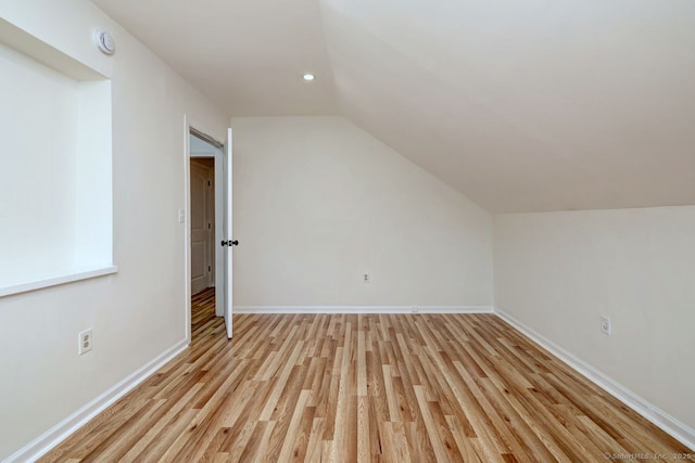 additional living space with lofted ceiling, light wood-type flooring, recessed lighting, and baseboards