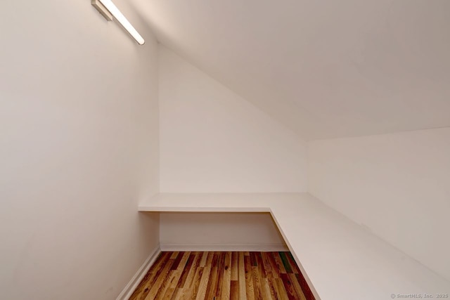 walk in closet featuring lofted ceiling and wood finished floors