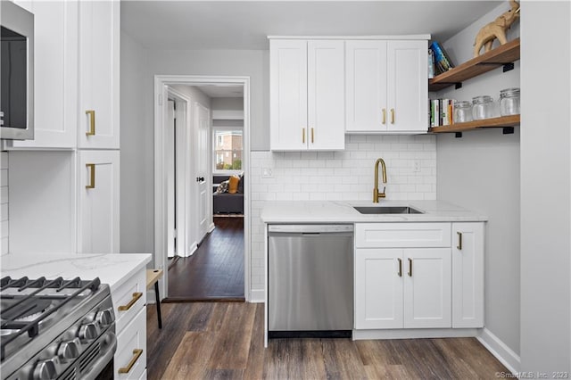 kitchen featuring stainless steel dishwasher, a sink, backsplash, dark wood-style floors, and white cabinets