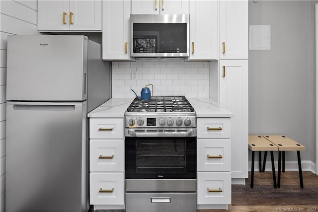 kitchen featuring stainless steel appliances, dark wood-style floors, light stone counters, decorative backsplash, and white cabinets