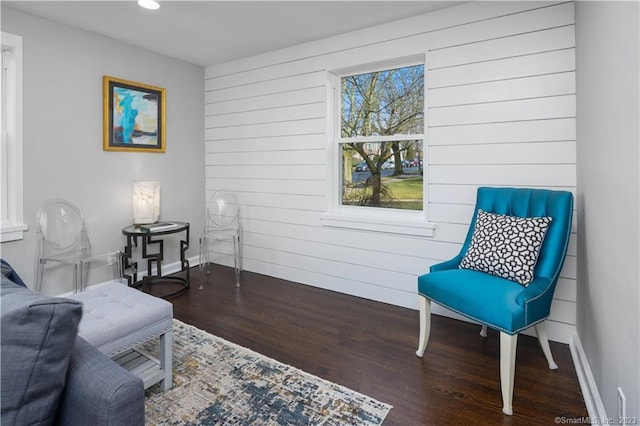 sitting room featuring wood finished floors, baseboards, wooden walls, and recessed lighting