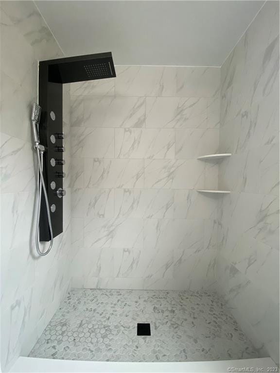 full bathroom featuring tiled shower