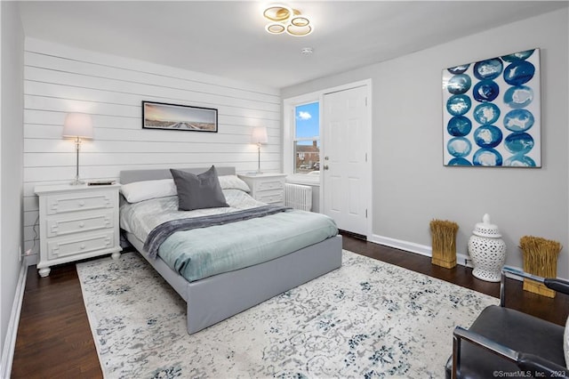 bedroom with baseboards, radiator heating unit, and dark wood-style floors