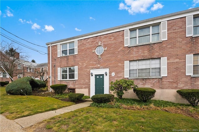 view of front of house featuring a front yard and brick siding