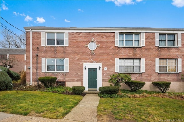 view of front of property with a front lawn and brick siding