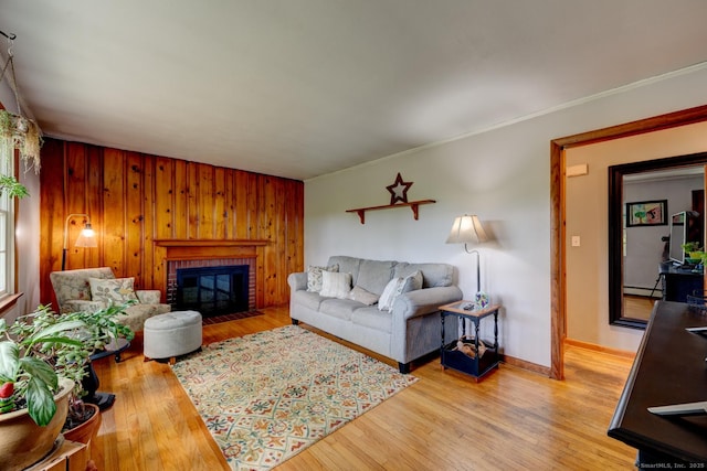 7 Parker Rd, Willington, CT 06279 - living room featuring light wood-type flooring, a brick fireplace, baseboard heating, ornamental molding, and wood walls