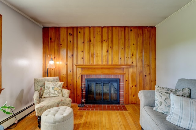 7 Parker Rd, Willington, CT 06279 - living area featuring a baseboard radiator, a brick fireplace, wood finished floors, crown molding, and wood walls