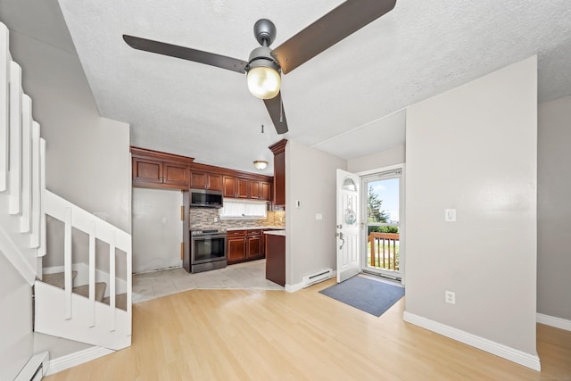 kitchen featuring stainless steel appliances, a baseboard radiator, tasteful backsplash, ceiling fan, and light wood-style floors