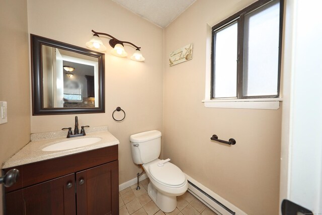 bathroom with toilet, vanity, baseboards, tile patterned floors, and a baseboard radiator