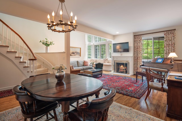 44 Hale Ln, Darien, CT 06820 - dining space featuring wood finished floors, stairway, a chandelier, a lit fireplace, and recessed lighting