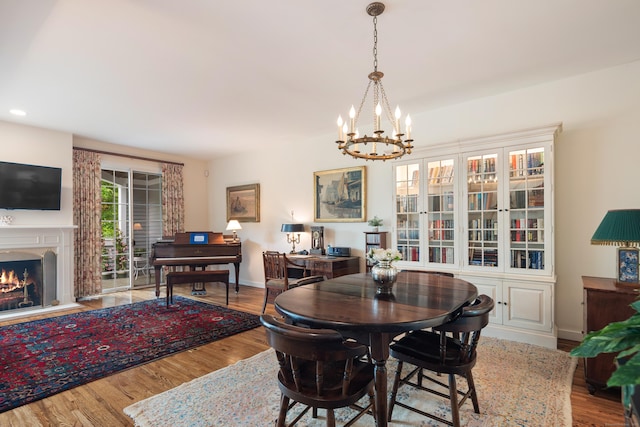 44 Hale Ln, Darien, CT 06820 - dining space featuring a chandelier, wood finished floors, a warm lit fireplace, baseboards, and recessed lighting