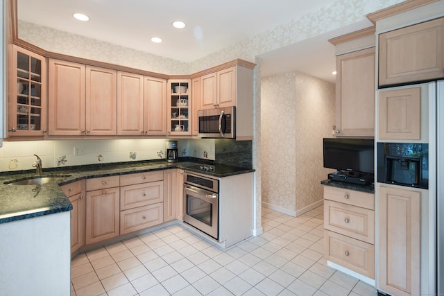 44 Hale Ln, Darien, CT 06820 - kitchen with stainless steel appliances, wallpapered walls, a sink, light brown cabinets, and glass insert cabinets