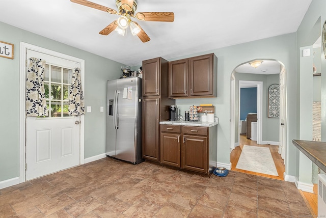 173 Columbia St, New Britain, CT 06052 - kitchen featuring stainless steel refrigerator with ice dispenser, arched walkways, ceiling fan, baseboards, and light stone finish floors