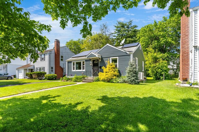 173 Columbia St, New Britain, CT 06052 - view of front facade with a front lawn, roof mounted solar panels, and central air condition unit