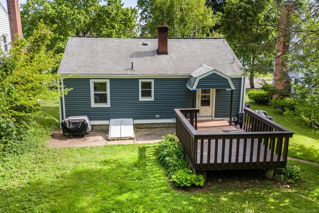 173 Columbia St, New Britain, CT 06052 - rear view of house featuring a lawn, a deck, a chimney, roof with shingles, and view of scattered trees