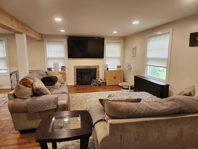 12 Flyers Dr, Norwich, CT 06360 - living room with wood finished floors, a brick fireplace, recessed lighting, radiator heating unit, and baseboards