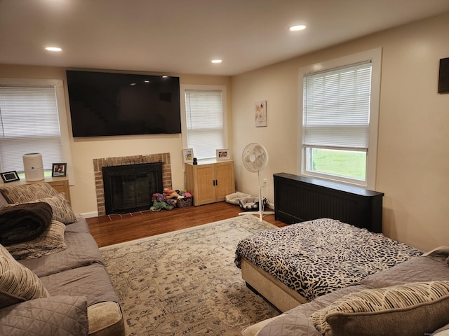 12 Flyers Dr, Norwich, CT 06360 - living room with radiator, wood finished floors, healthy amount of natural light, recessed lighting, and a fireplace