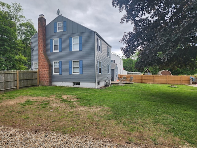 12 Flyers Dr, Norwich, CT 06360 - rear view of property featuring a chimney and board and batten siding