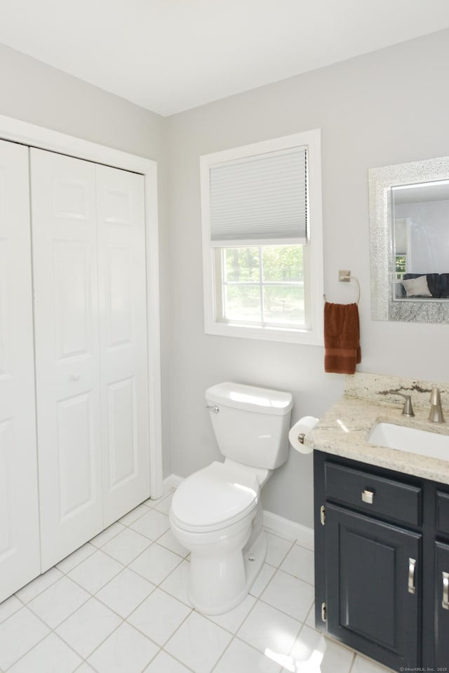 bathroom featuring baseboards, toilet, vanity, and tile patterned floors