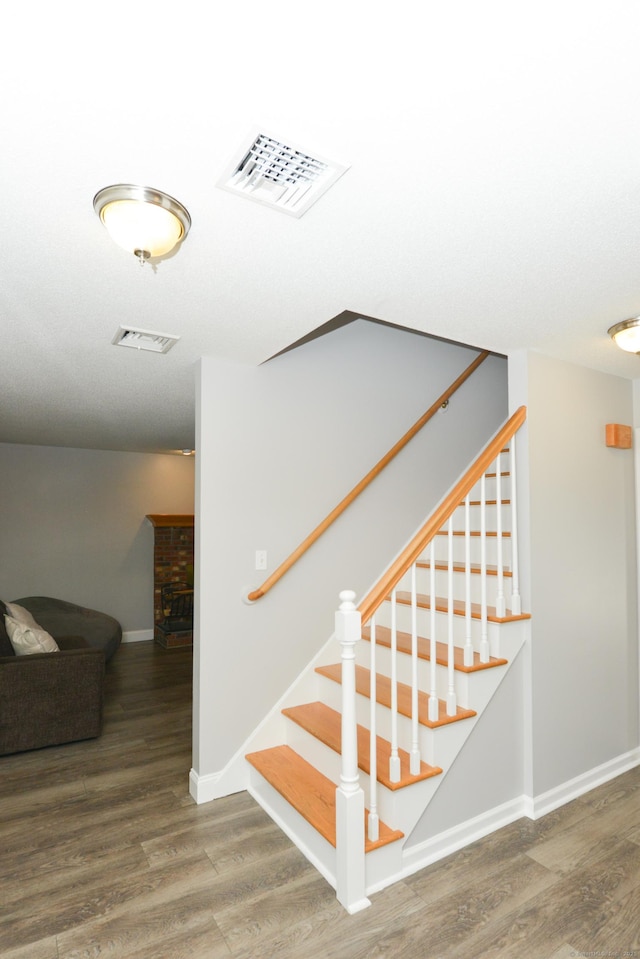 staircase featuring baseboards and wood finished floors