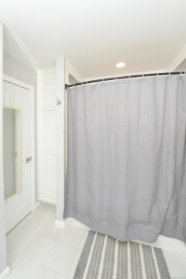 bathroom with curtained shower and baseboards