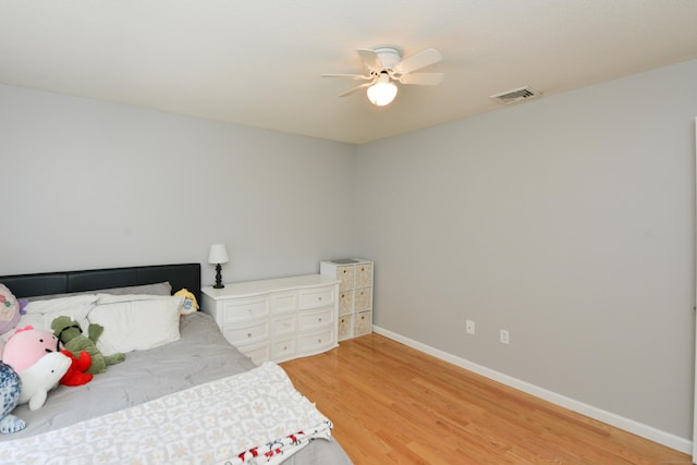 bedroom with light wood-style floors, baseboards, and ceiling fan