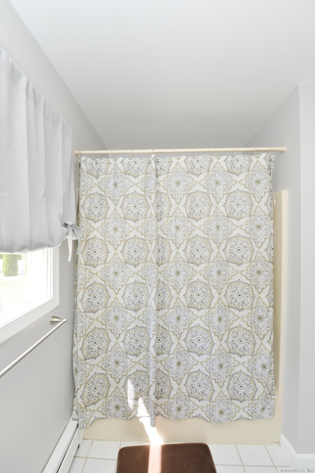 full bathroom featuring tile patterned flooring, a shower with shower curtain, and baseboard heating