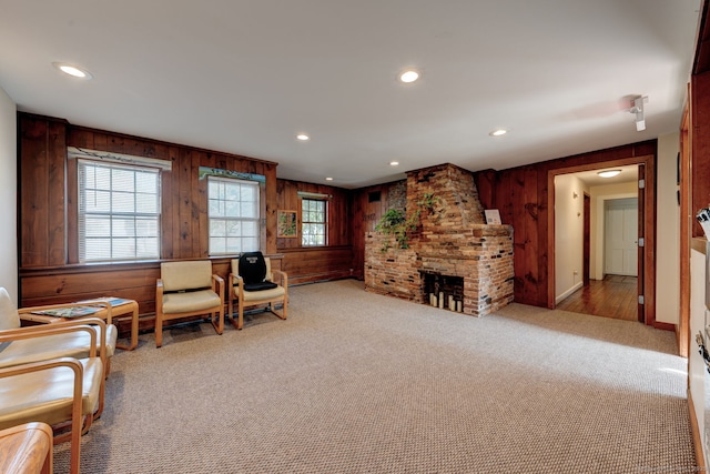 living area with wooden walls, carpet floors, recessed lighting, baseboards, and a fireplace