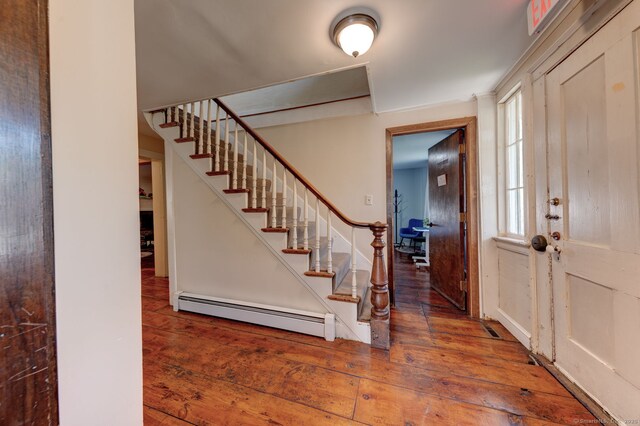 foyer entrance featuring a baseboard radiator, hardwood / wood-style floors, and stairway