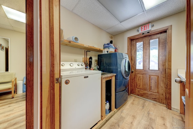 laundry room with light wood-type flooring and washer and clothes dryer