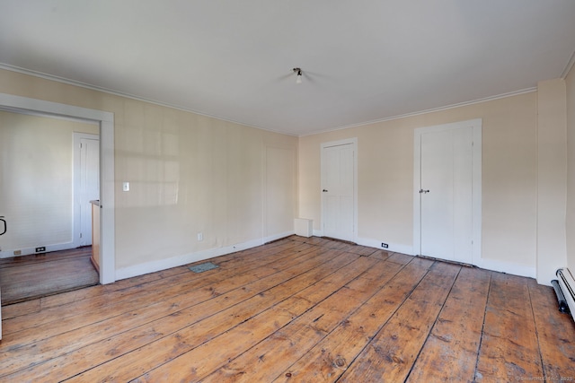 unfurnished room featuring crown molding, hardwood / wood-style floors, and baseboards