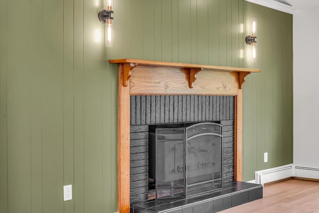 636 Thompson Rd, Thompson, CT 06277 - detailed view of a fireplace with raised hearth, wood finished floors, and a baseboard radiator