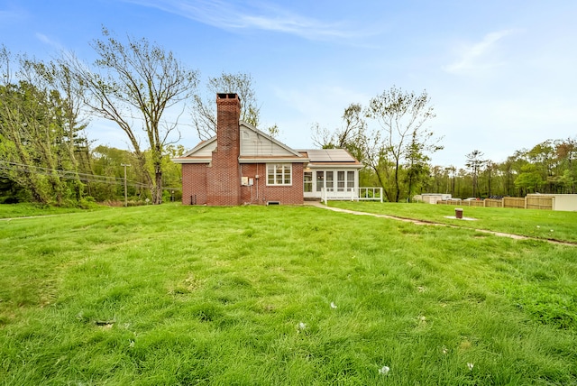 636 Thompson Rd, Thompson, CT 06277 - back of property featuring a sunroom, a chimney, solar panels, and brick siding