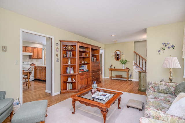 living area featuring light wood-type flooring, stairs, recessed lighting, and baseboards