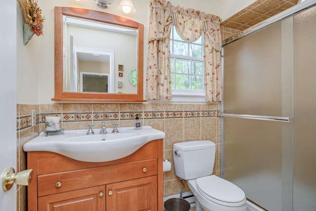 full bath featuring a stall shower, toilet, vanity, tile walls, and a wainscoted wall