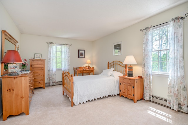 bedroom featuring light colored carpet and a baseboard heating unit