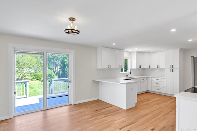 192 Morgan Cir, Wethersfield, CT 06109 - kitchen featuring a peninsula, white cabinets, light wood finished floors, recessed lighting, and light countertops