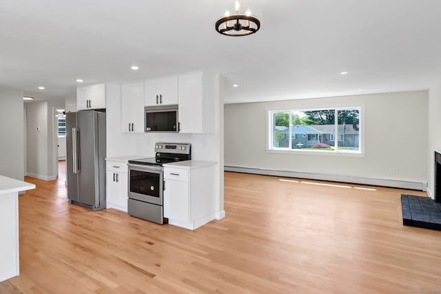 192 Morgan Cir, Wethersfield, CT 06109 - kitchen with appliances with stainless steel finishes, light wood-type flooring, a baseboard radiator, white cabinetry, and a chandelier