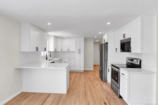 192 Morgan Cir, Wethersfield, CT 06109 - kitchen with stainless steel appliances, light wood-style flooring, a sink, light countertops, and a peninsula
