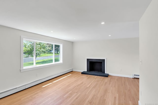 192 Morgan Cir, Wethersfield, CT 06109 - unfurnished living room featuring a baseboard heating unit, light wood-style flooring, a fireplace with raised hearth, baseboards, and recessed lighting