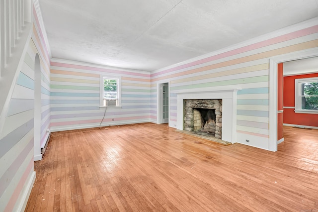 13 Hoyt Rd, Bethel, CT 06801 - unfurnished living room featuring hardwood / wood-style flooring, baseboards, ornamental molding, a stone fireplace, and wallpapered walls