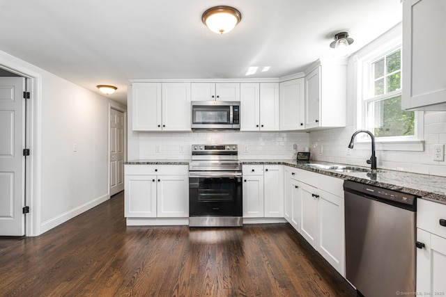 17 Emily Rd, East Windsor, CT 06016 - kitchen featuring stainless steel appliances, a sink, backsplash, dark wood-style flooring, and dark stone counters