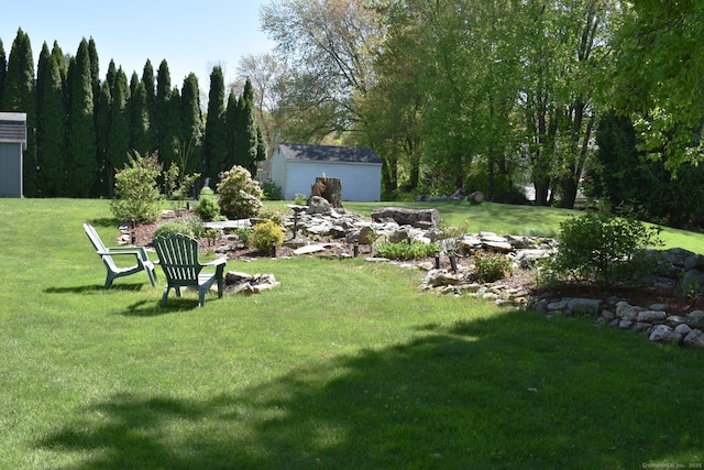 view of green lawn featuring an outbuilding