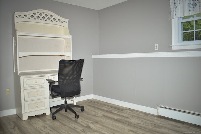 office area featuring baseboard heating, wood finished floors, and baseboards